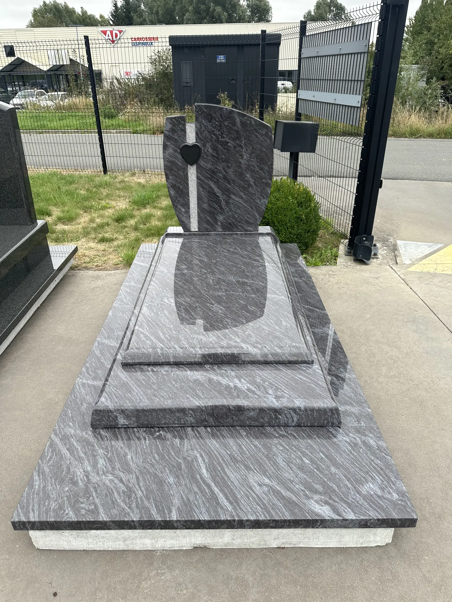 Monument funéraire contemporain à stèle voile en granit veiné, parc d'exposition de la Marbrerie Buchet à Wavrin